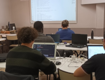 Étudiant devant des écrans de code